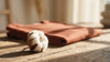 A cotton boll beside a folded Gravitee Atelier cotton tee.