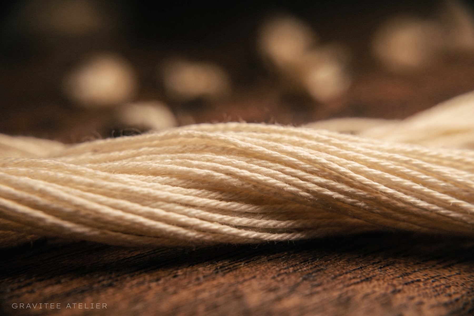 A skein of fine cotton yarn on a wooden surface, seen up close